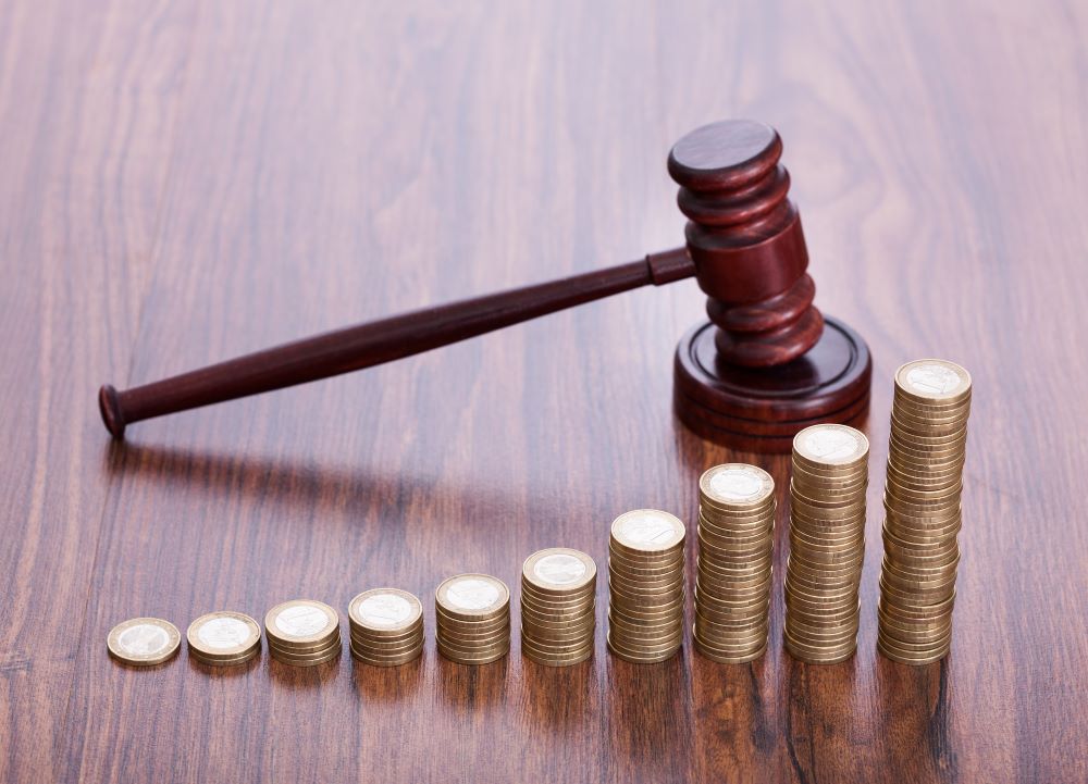 Pile de pieces de monnaie à coté d'un maillet d'avocat